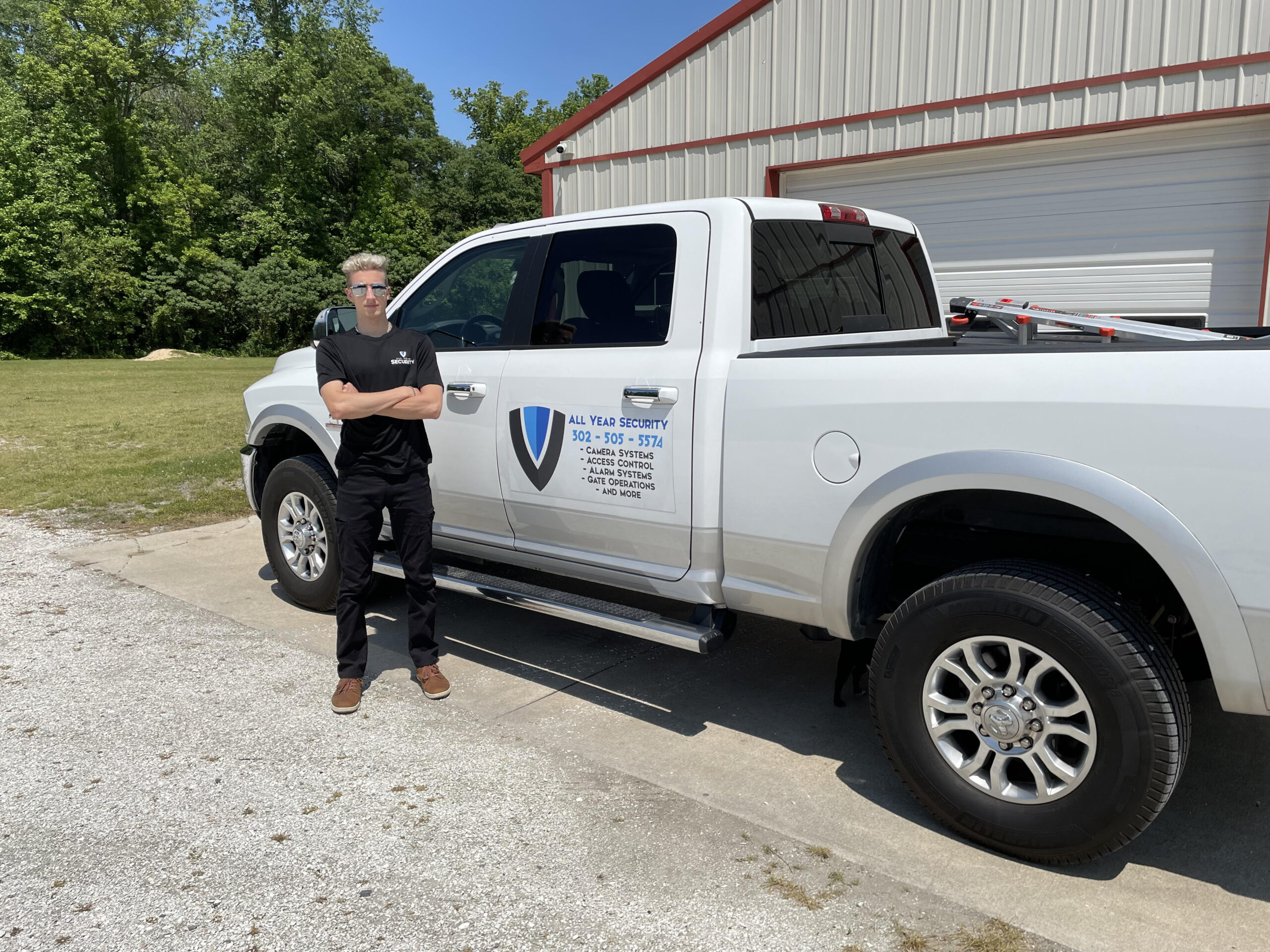 Owner of All Year Security standing beside company service truck in Delaware.